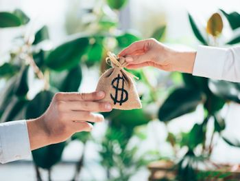 Hands passing money bag for project offering